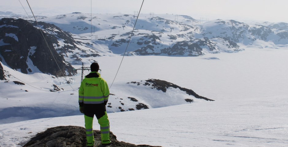Statnett-ansatt, ledning på snødekt fjell.